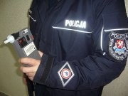 Policjant w mundurze z alkomatem w dłoni