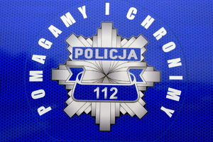 Policyjna gwiazda z napisem POMAGAMY I CHRONIMY