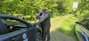 Policjanci i Strażnicy Leśni planują patrol terenu lasu
