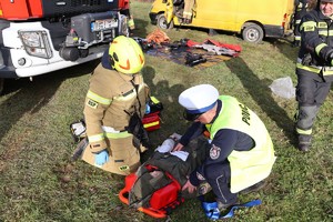 Policjant drogówki pomaga w udzielaniu pierwszej pomocy