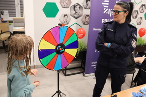 Policjantka z kołem loteryjnym i dziewczynką