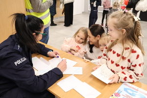Policjantka zadaje pytanie konkursowe dzieciom