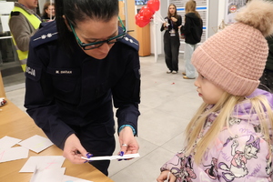 Policjantka czyta pytanie konkursowe dziewczynce