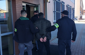 Policjanci prowadzą zatrzymanego - poszukiwanego