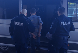 Policjanci prowadzą zatrzymanego - poszukiwanego