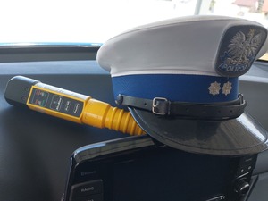 Wnętrze radiowozu, alkomat oraz czapka policjanta WRD