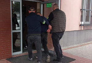 Policjanci prowadzą zatrzymanego sprawcę kradzieży