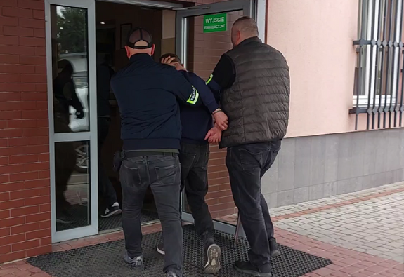 Policjanci prowadzą zatrzymanego sprawcę kradzieży